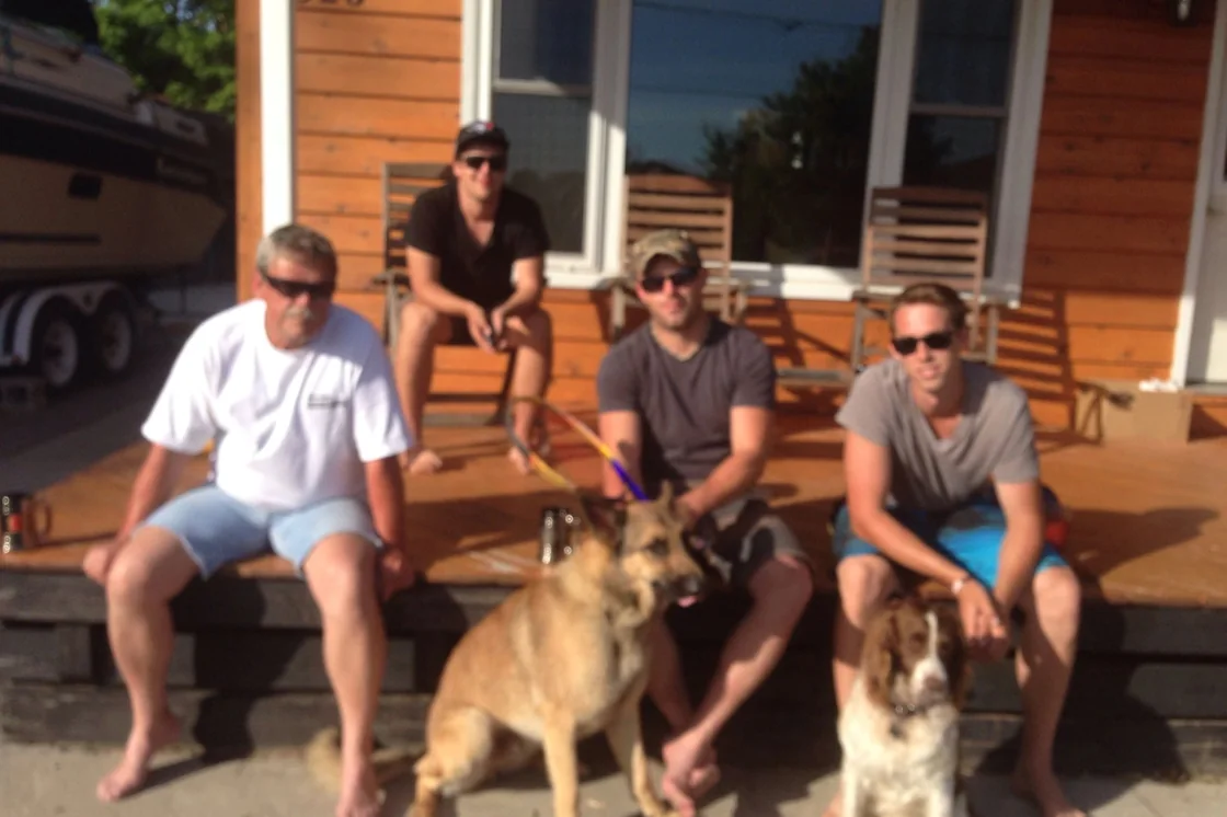 The Wamsley crew sitting on the front steps of a house with two dogs.