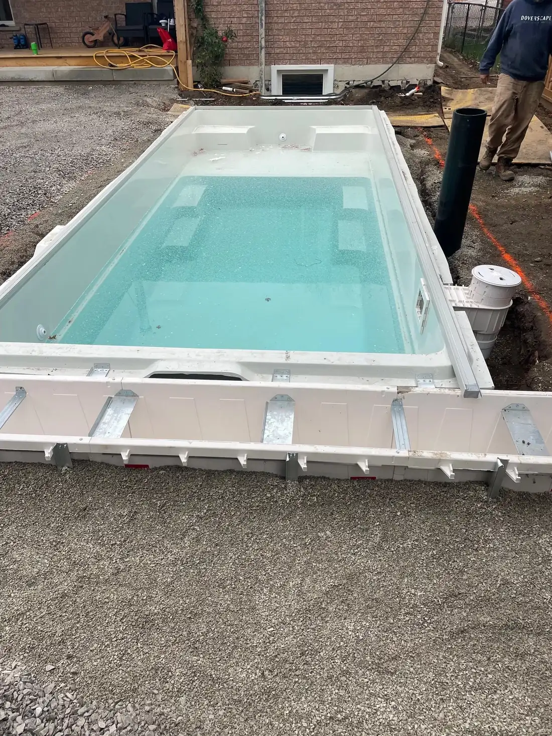 A swim spa being installed in a concrete deck.